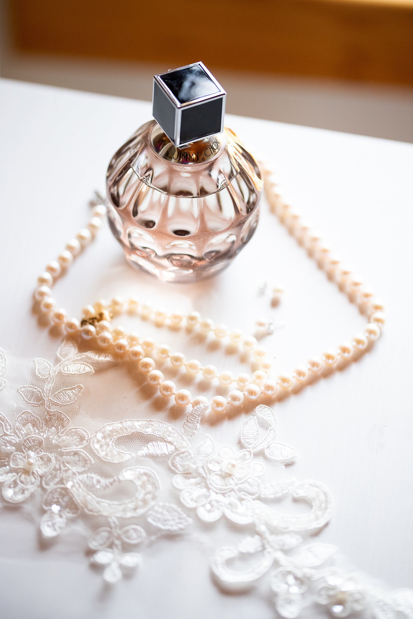 perfume, peral necklace, and lace at a wedding