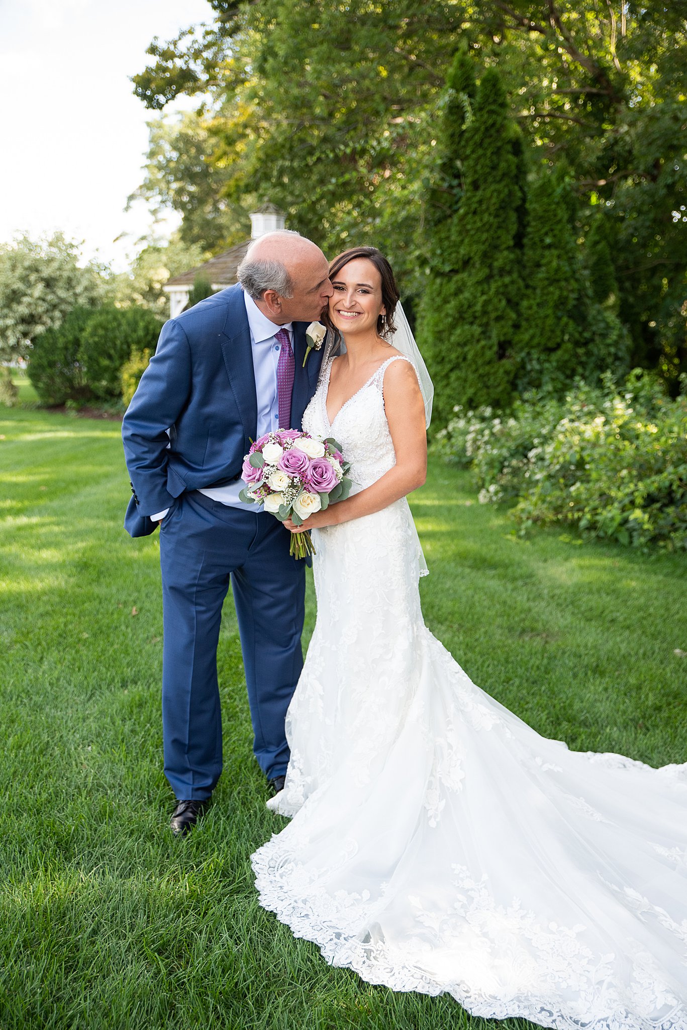 bride's father kissing her on the cheek before walking her down the aisle
