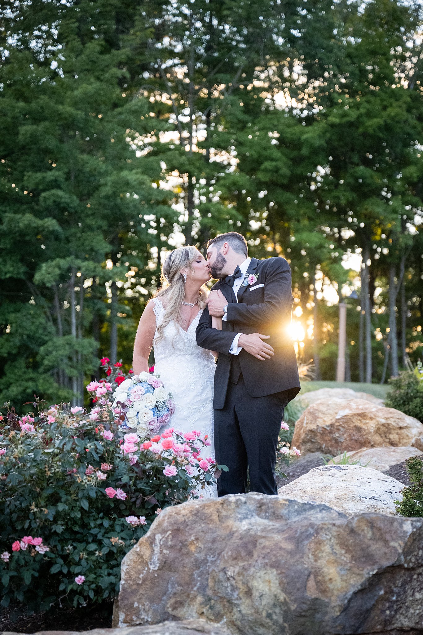 bride and groom kiss amongst large rocks and flowers Kirkbrae wedding